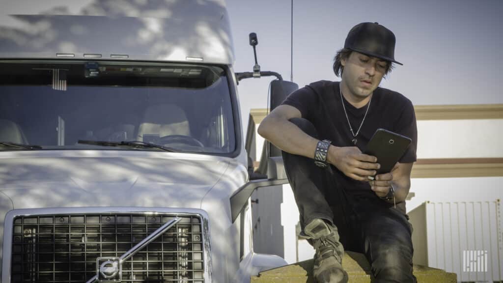 Image of a truck driver reviewing freight load sources on a tablet